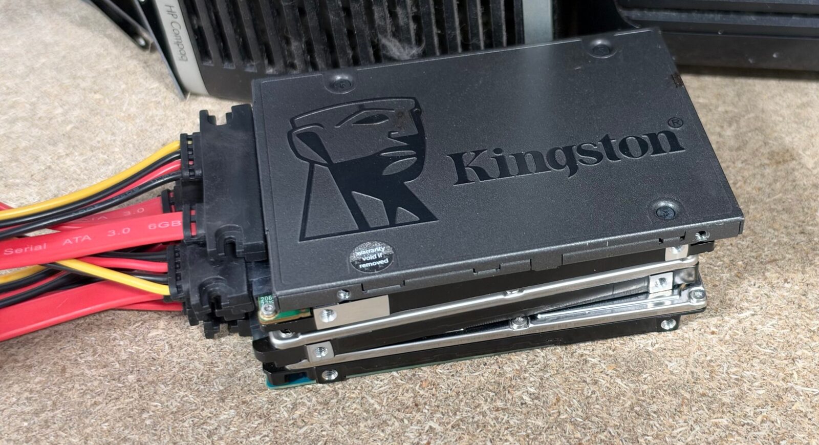 A stack of SSDs and hard drives connected by SATA cables for wiping at the Revolve ITAD facility